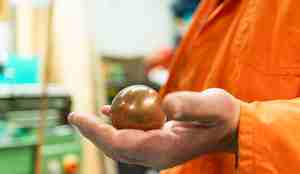 mann i oransje dress viser en kule