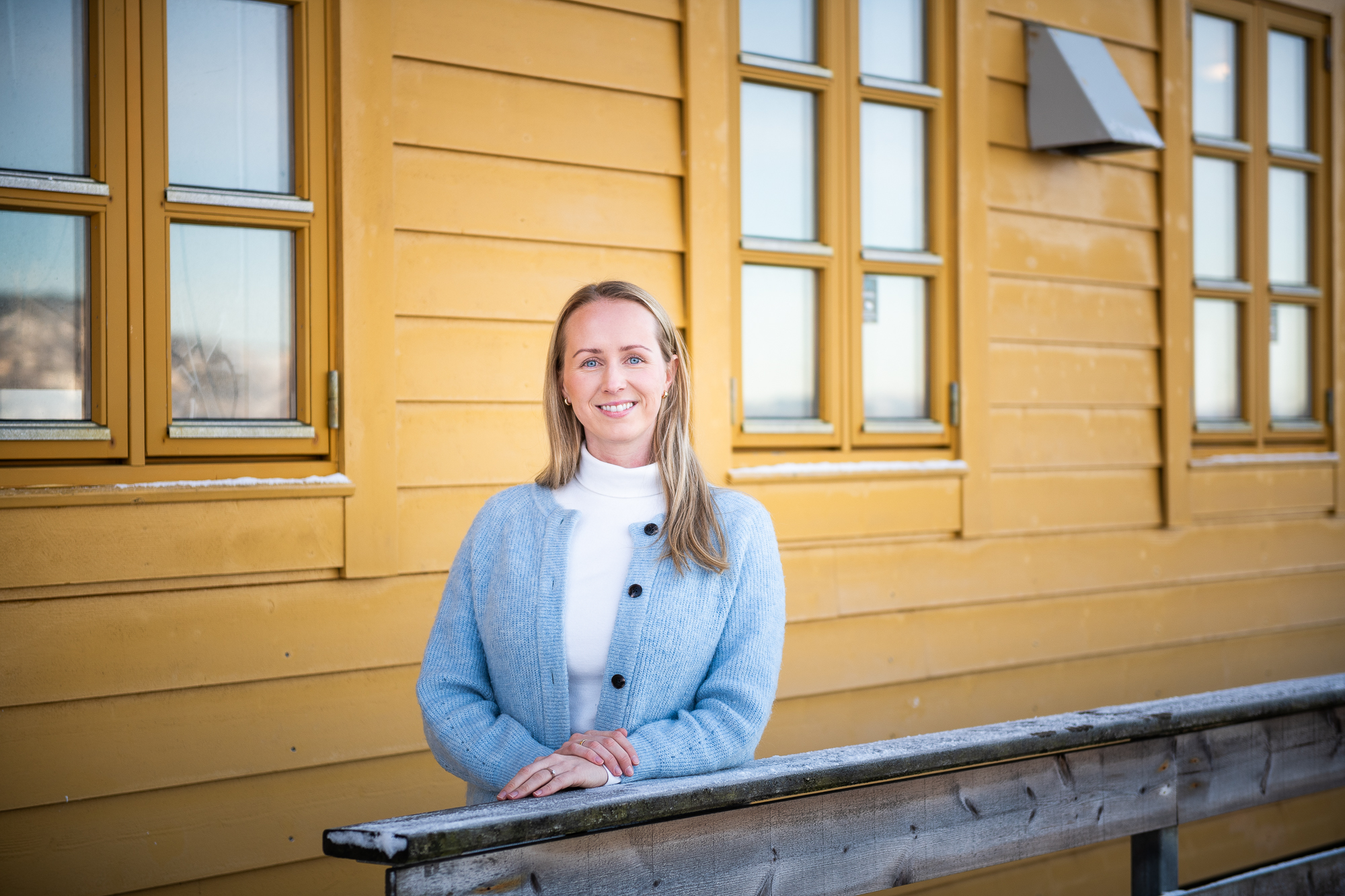 kvinne foran en gul vegg