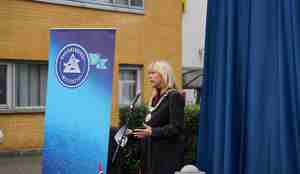 Bilde av Marit Warncke som holder tale foran bauta før avduking.