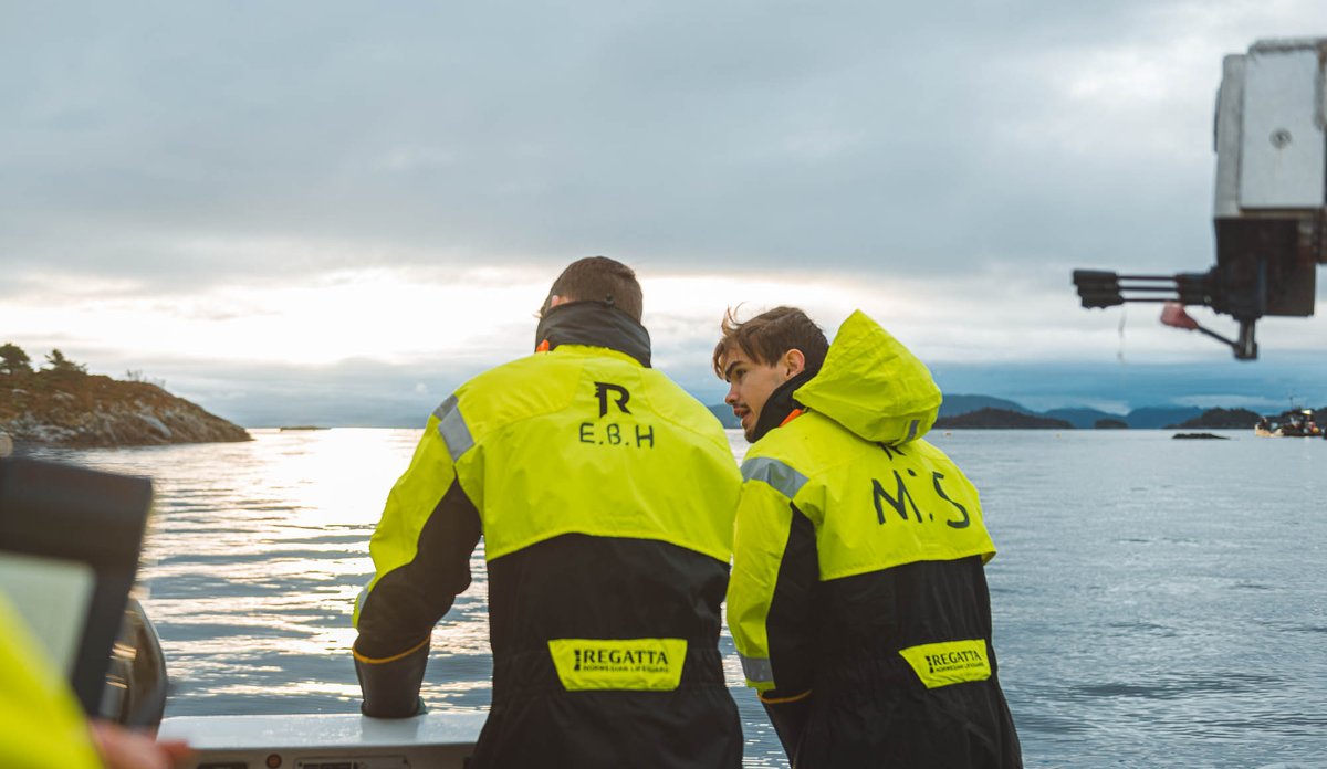 To elever står langs ripen og venter i soloppgangen.