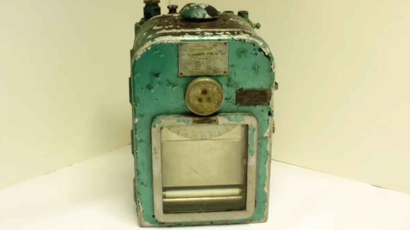 Bilde av et slitt, grønt og litt rustent gammelt ekkolodd.