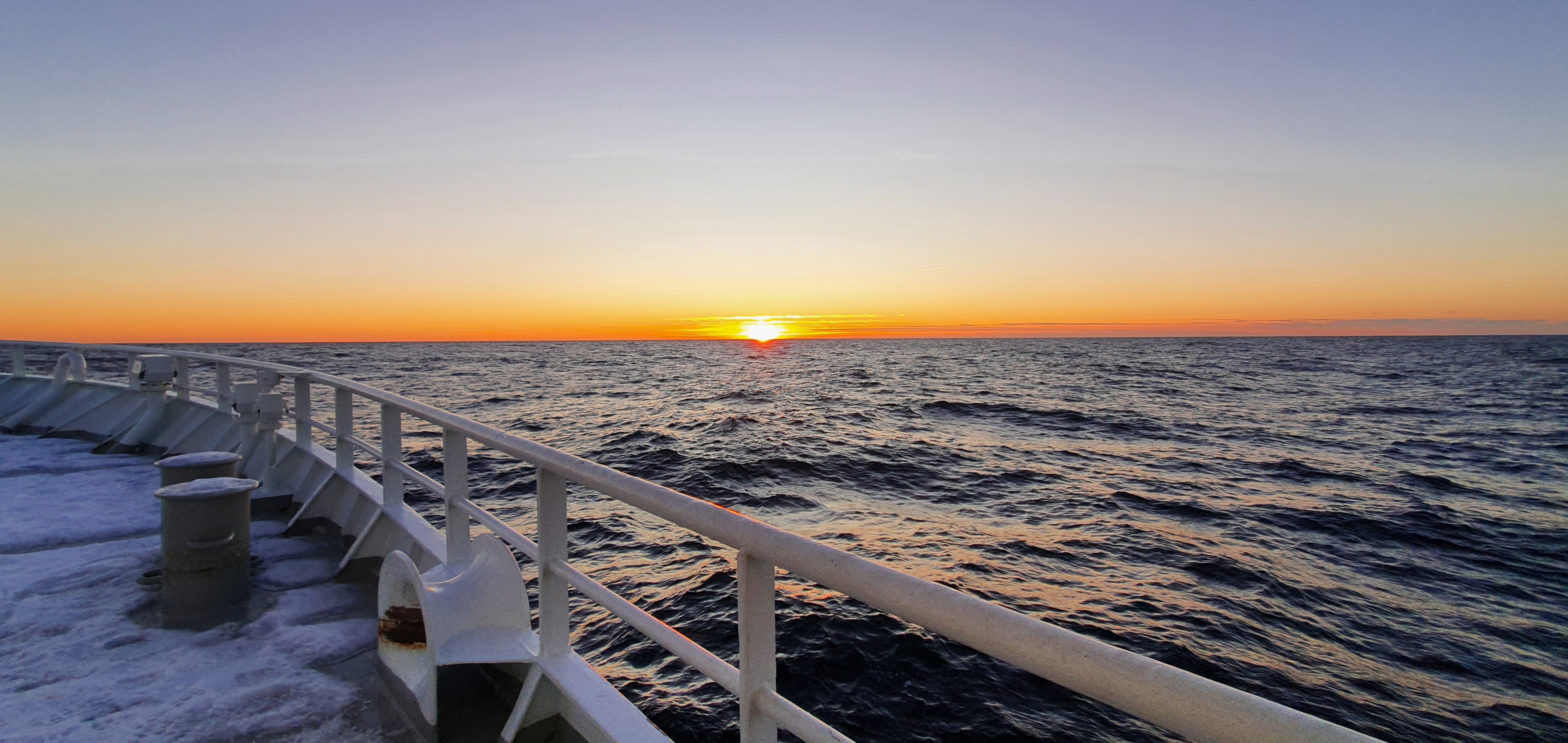 Utsikt over ripa på eit fartøy. Sola er i ferd med å gå ned i horisonten