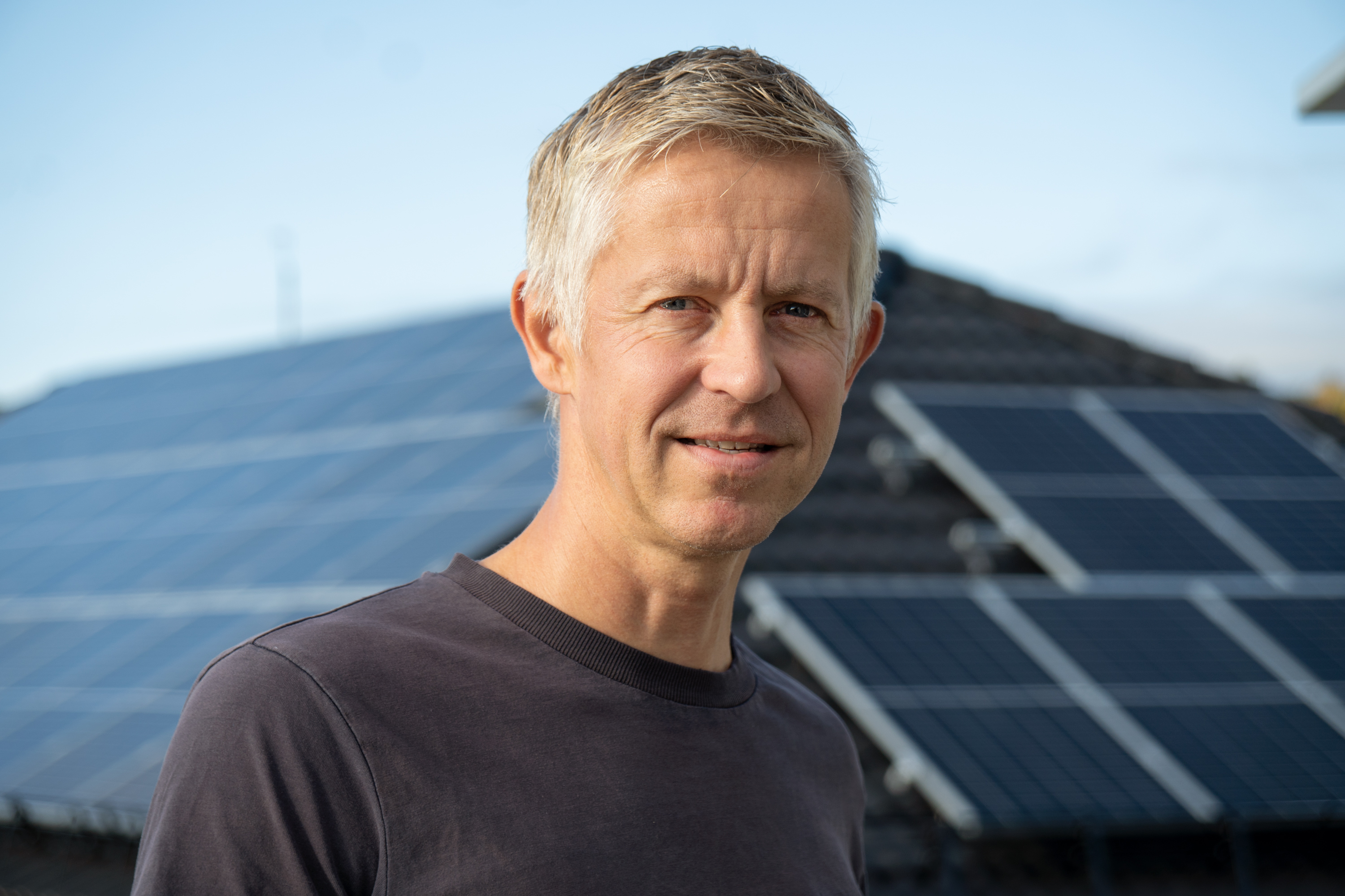 mann i t-skjorte ser i kamera med nøytralt ansikt