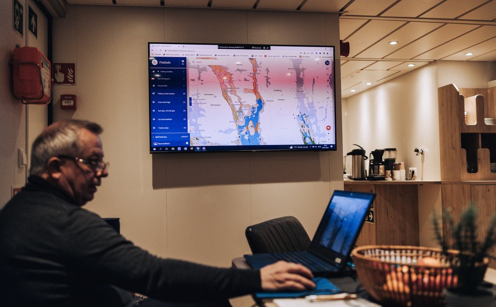foto av mann inni skip med skjerm og kart