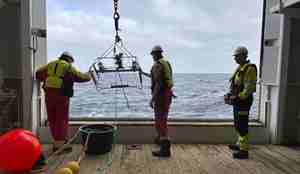 foto av menn foran sjø med en dings i tau