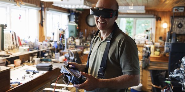 

foto av mann på verksted med en slags robot på et bord