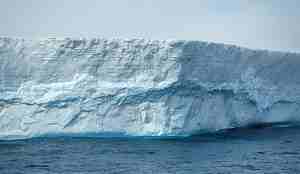 vegg av blålig is flytende i vannet 