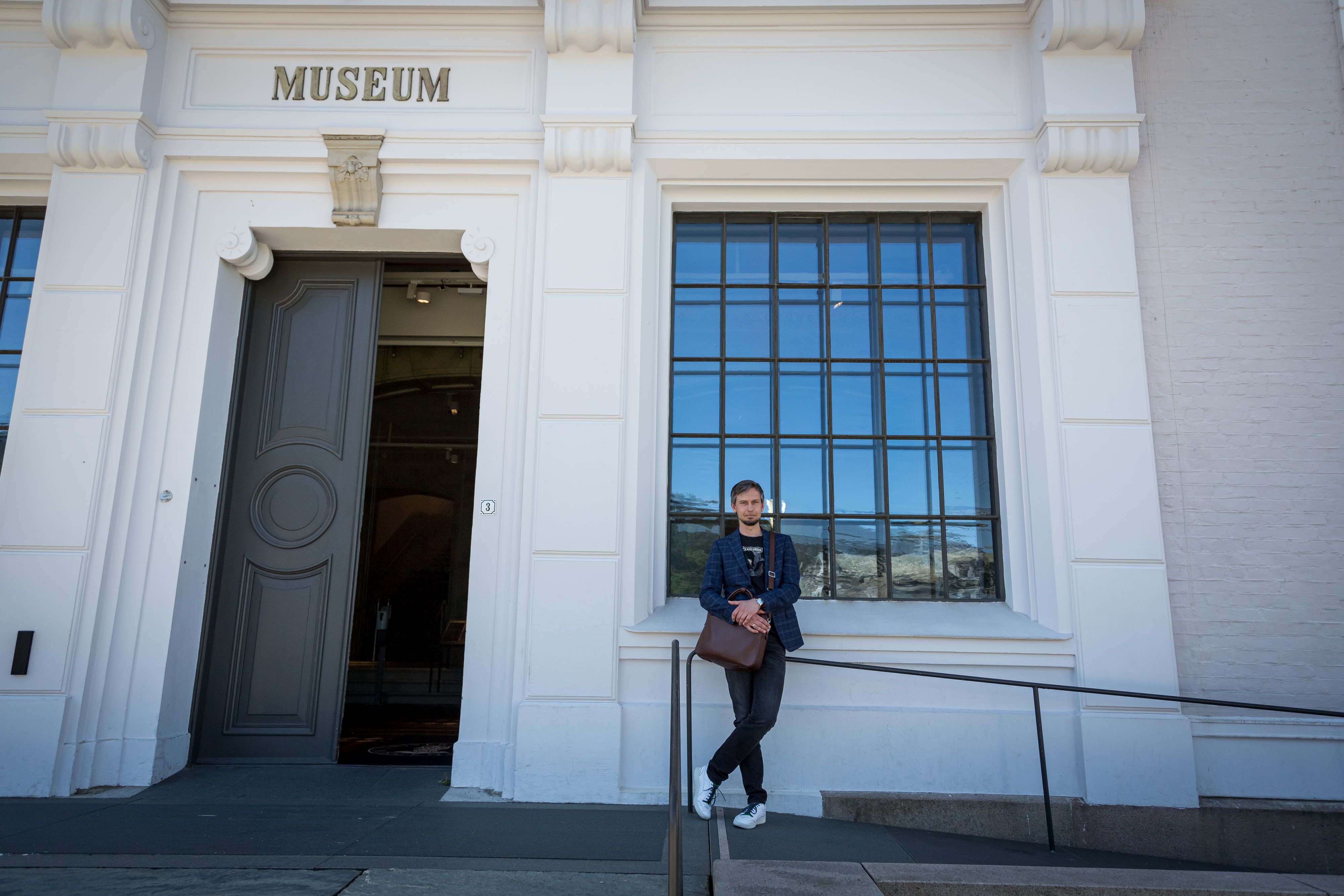 mann lener seg mot bygg