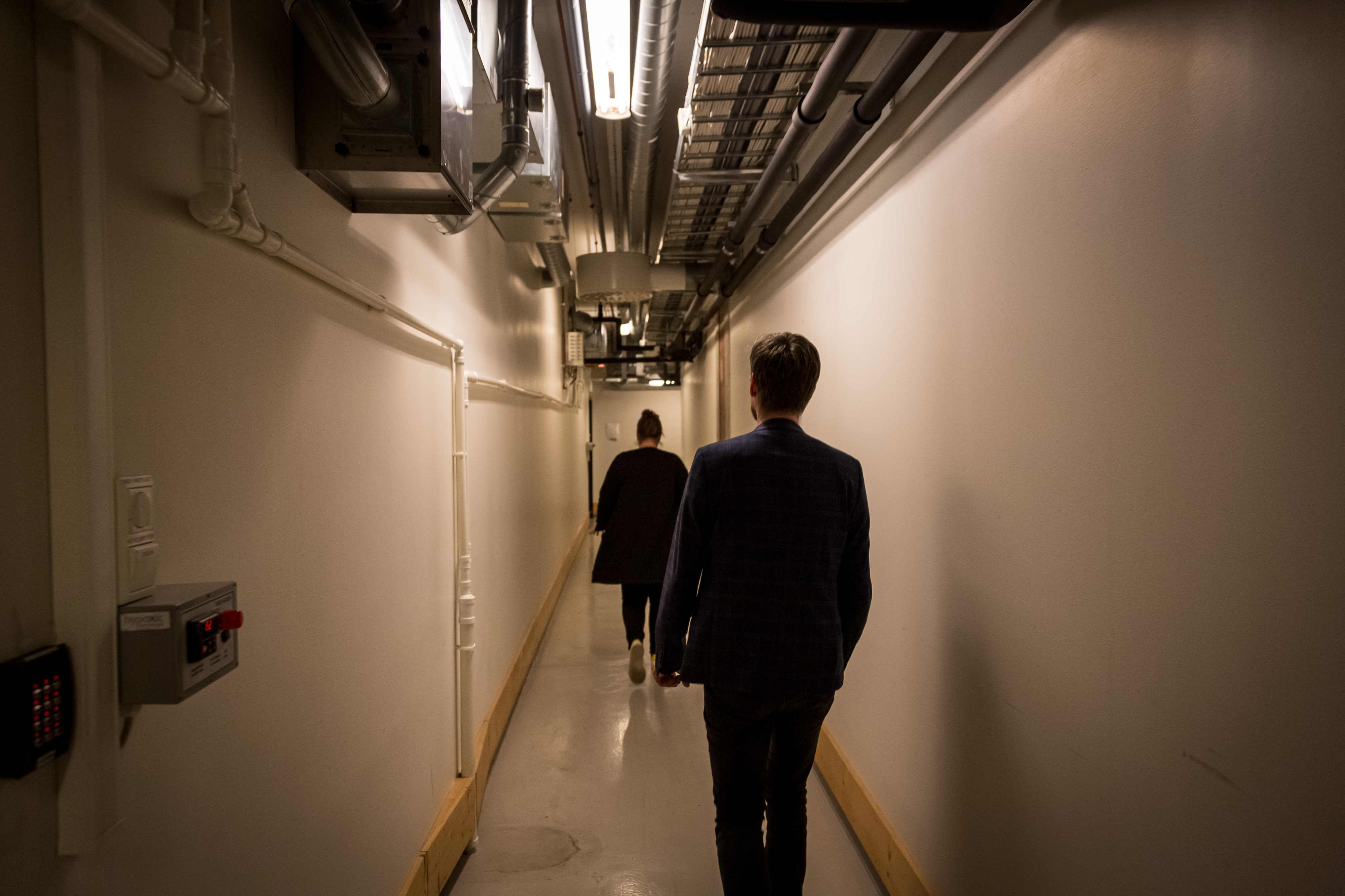 kvinne og mann går ned lang hvit gang