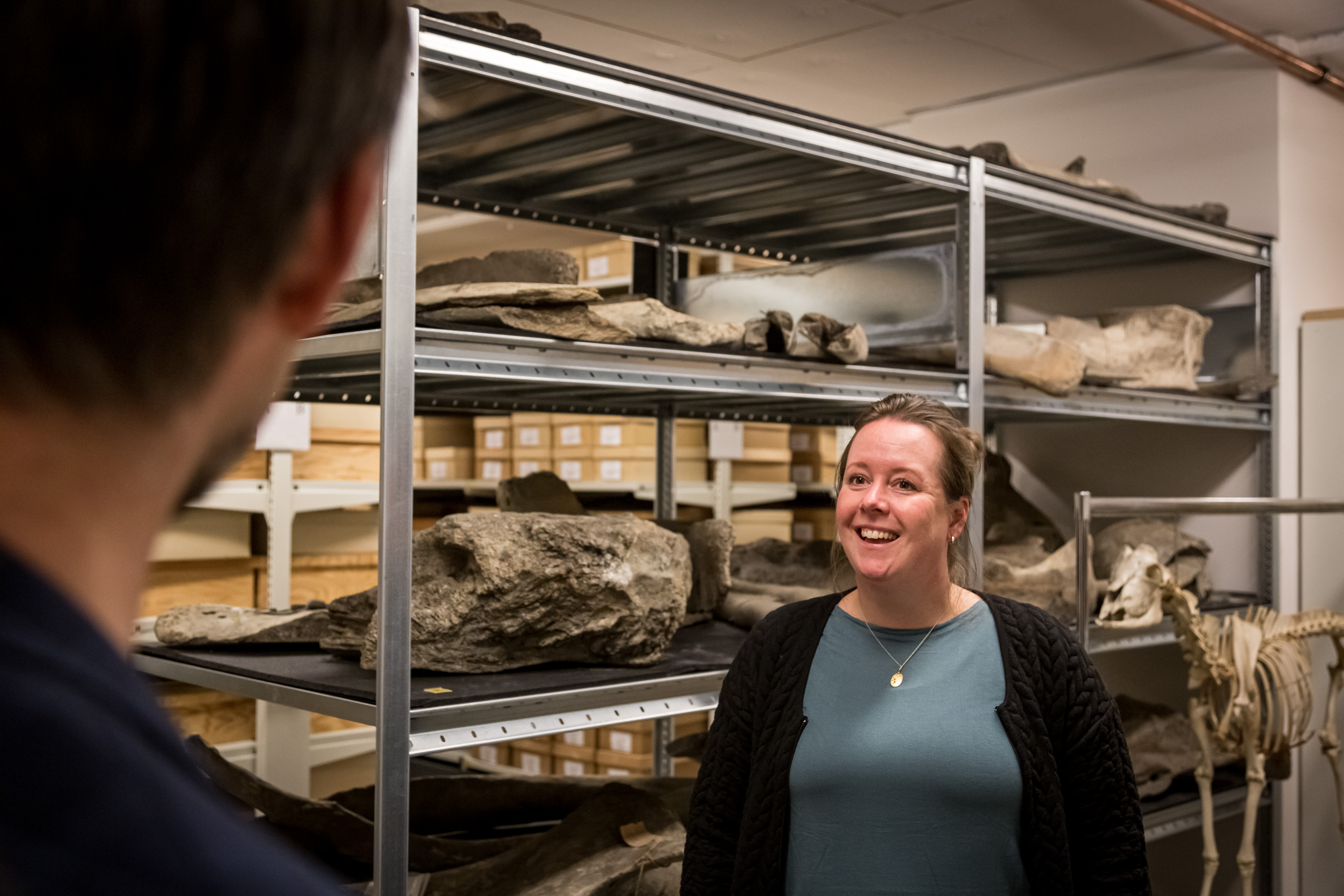 kvinne smiler mot mann, knokler på hylle bak 