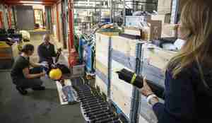 foto av tre folk og mange sylindere på gulvet