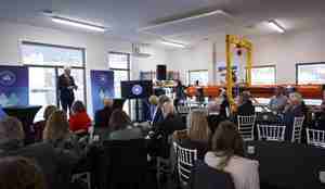 En mann holder en tale foran et fullsatt rom