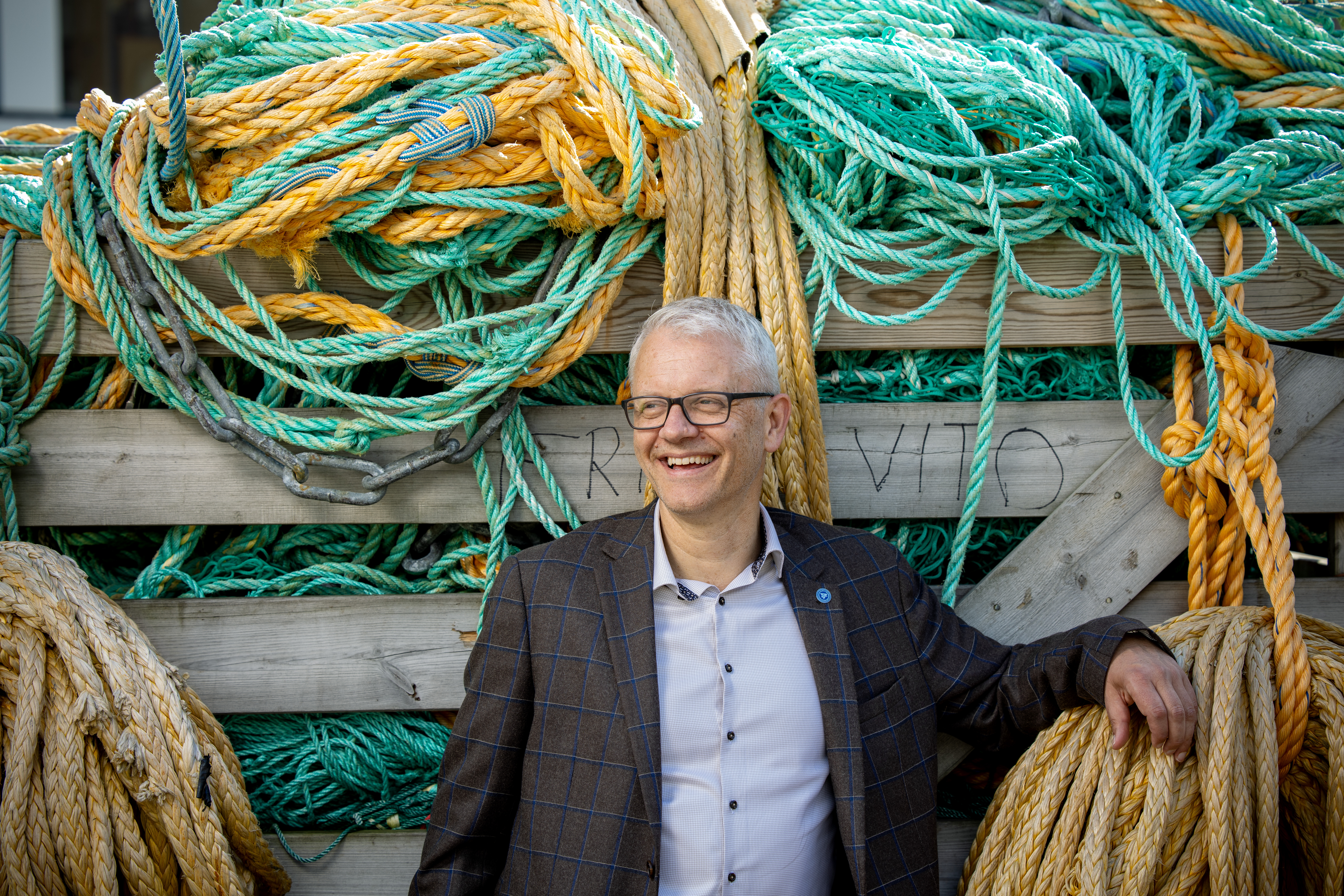 smilende mann lener seg på taukveil