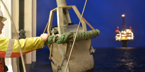 

Prøvetakningsutstyr på vei fra båt og ned i havet, like ved en oljeplattform