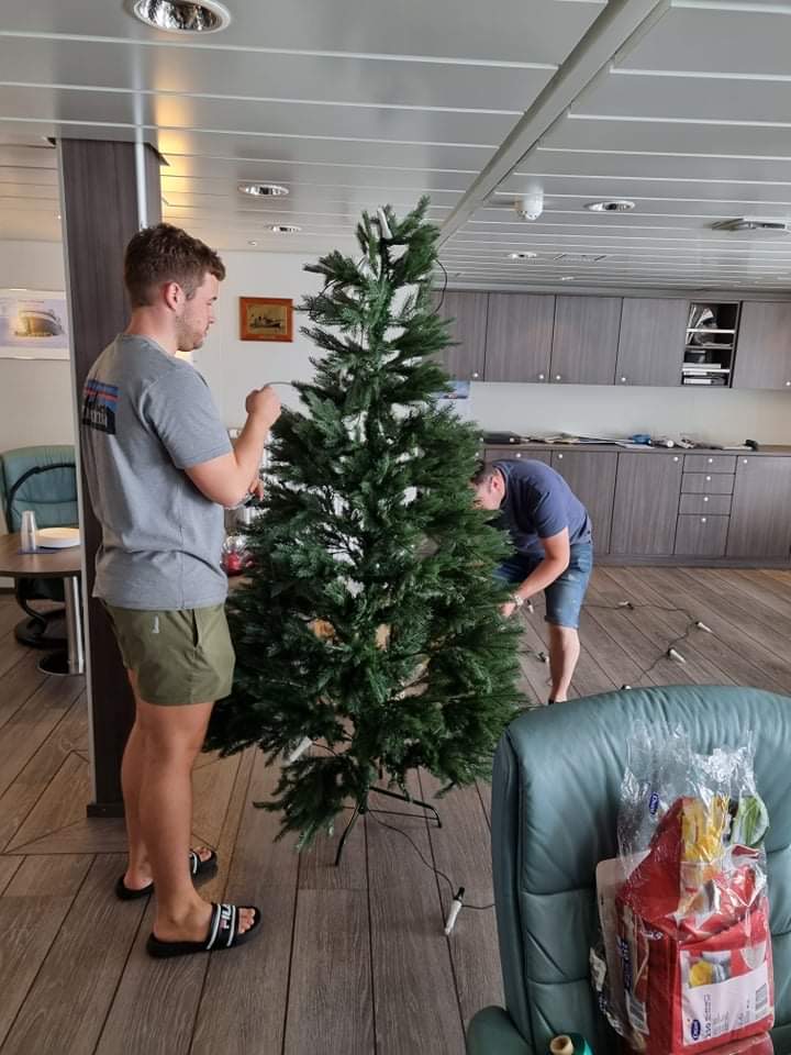 To menn pynter juletreet