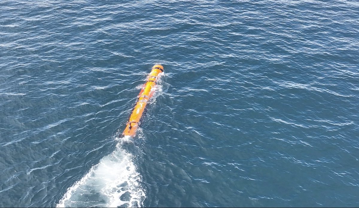 
Lang oransje sylinder kjører gjennom vannet.