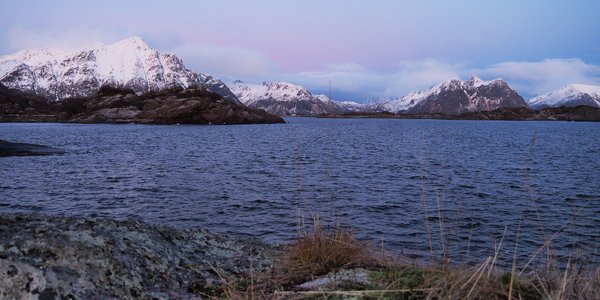 

Foto av fjor og snødekte fjell, himmel med kveldslys farga i blåtoner.