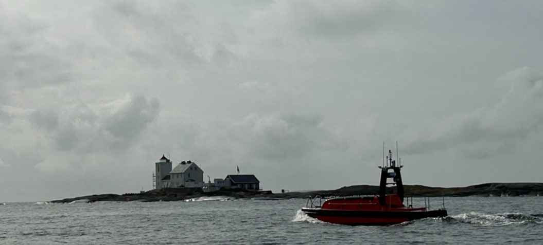 Bildet viser dronebåten "Frigg" i forgrunnen og Fulehuk fyr i bakgrunnen