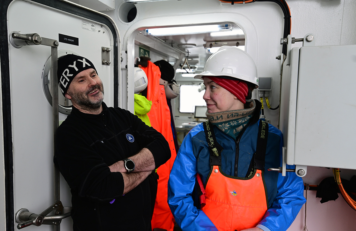To havforskere står sammen på dekk, begge smiler.