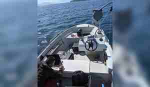 Mann og utstyr i småbåt på fjorden.