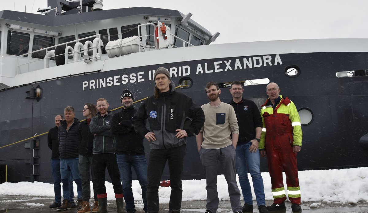 9 personer som deltar på toktet står oppstilt foran båten før avgang.